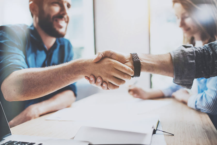 customer shaking hands after signing contract with finance outsourcing provider