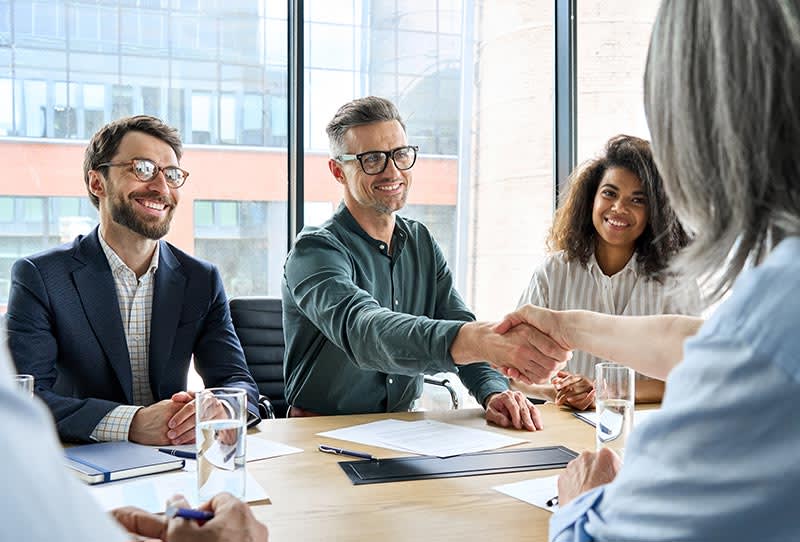 Finance leaders from two distinct companies meeting before merger