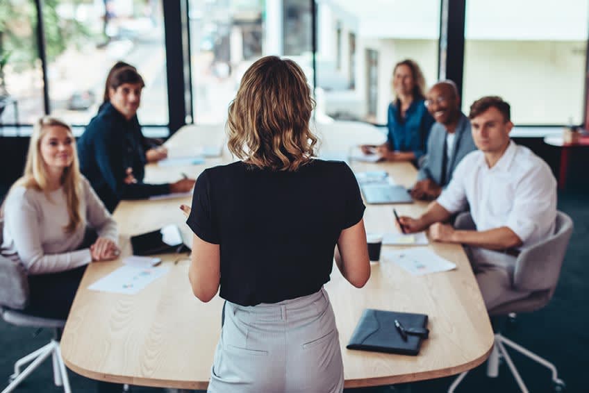 business consultant addressing a meeting about outsourcing to colleagues