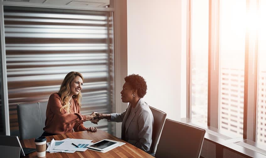 tech CEO closing deal with accounting outsourcing company in meeting room