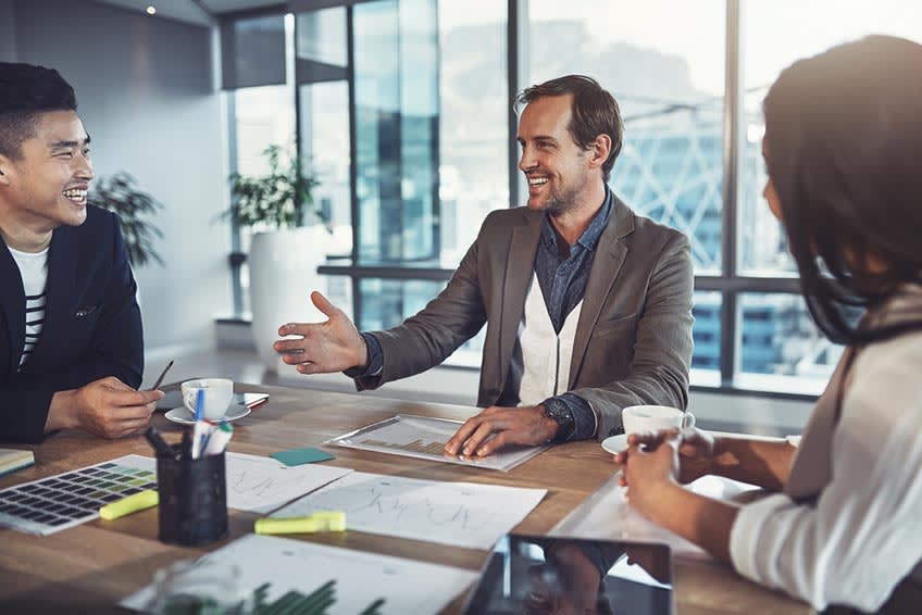 outsourcing supervisor checking on wealth management project employees during meeting