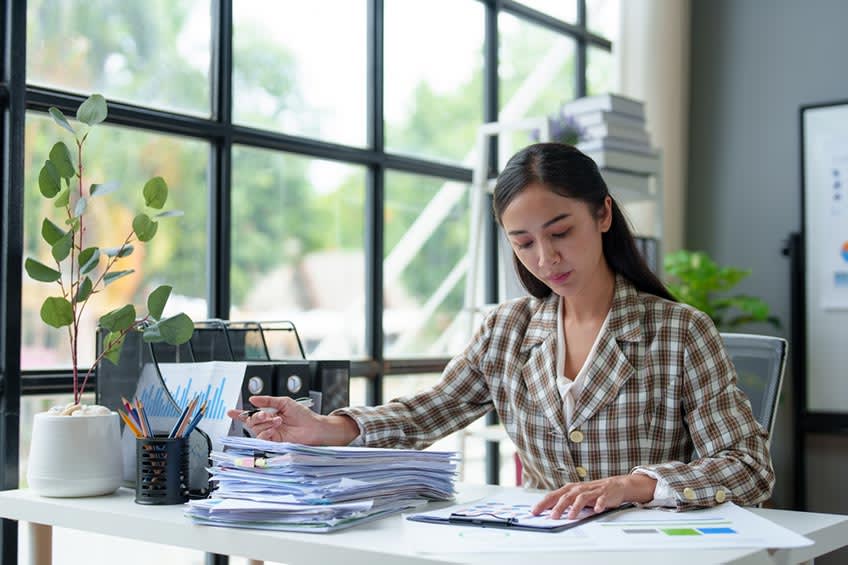 in-house real estate accountant working on stack of paperwork