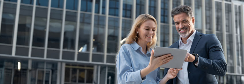 CEO and CFO comparing accounting outsourcing companies on their tablet