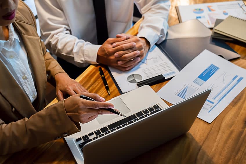 accountant showing new bookkeeper her responsibilities in their business