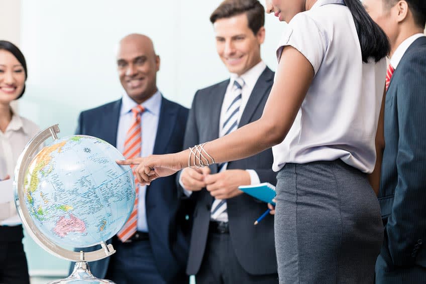 corporate leaders looking at world globe in a meeting with their new offshoring partner