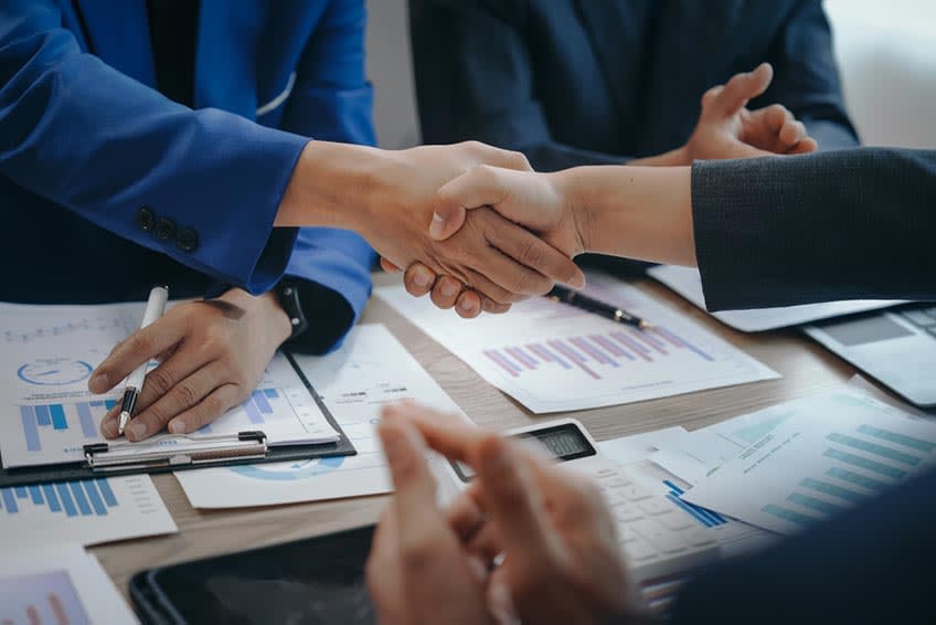 US business owner shaking hands with accounting outsourcing firm leaders