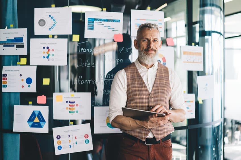 CEO in front of glass wall with different data driven stats for meetings