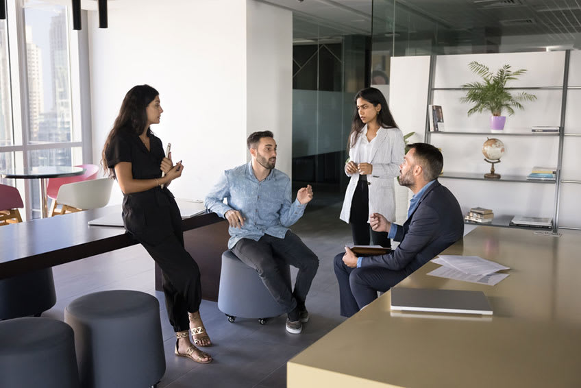 executive team having an informal discussion about the right timing for their company to outsource