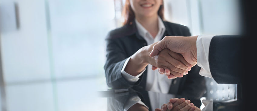 CEO in meeting closing deal and shaking hands with bookkeeping outsourcing representative from Personiv