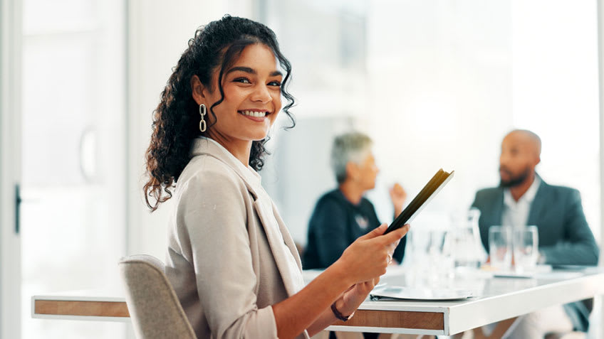 Bookkeeping team in meeting female employee smiling to the camera