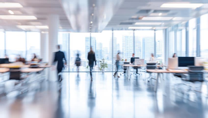 Blurred modern office with few people working after company decided to outsource