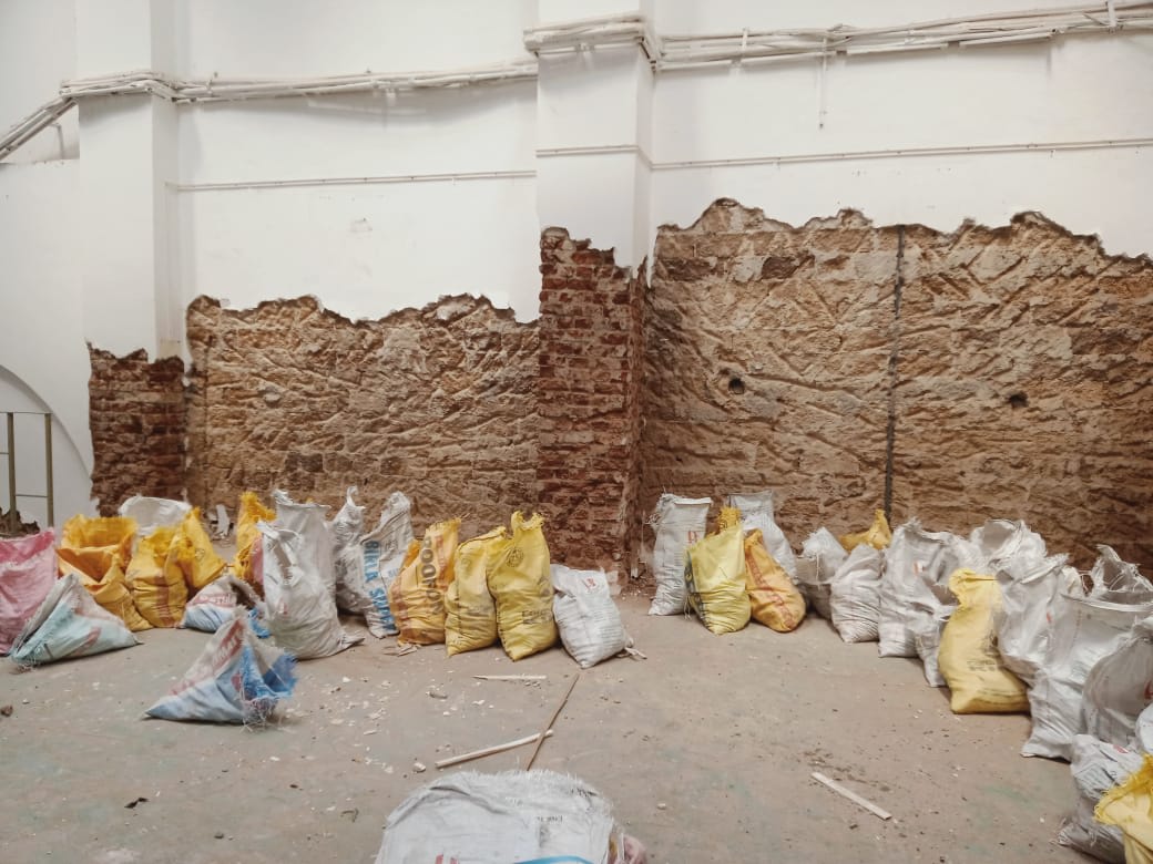 Work in progress image showing the brick wall under plaster and paint