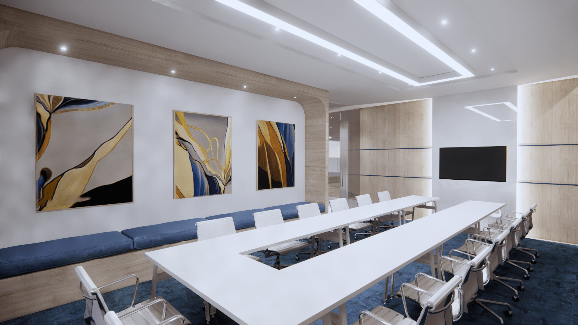 A commercial conference room with a large U-shaped table, a TV on the right wall, art and cushioned bench seating parallel to the table.