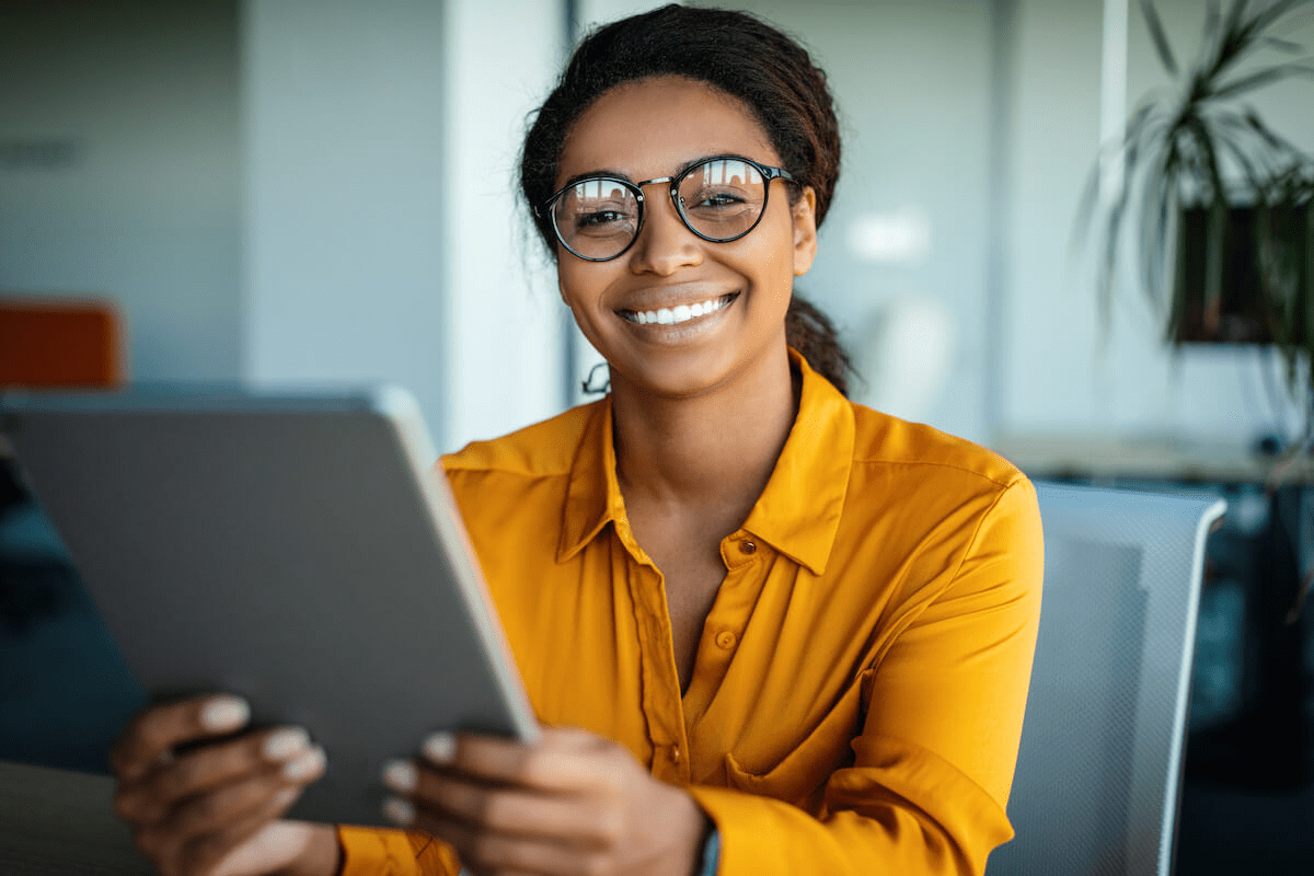 Timekeeping systems: entrepreneur holding a tablet while smiling at the camera