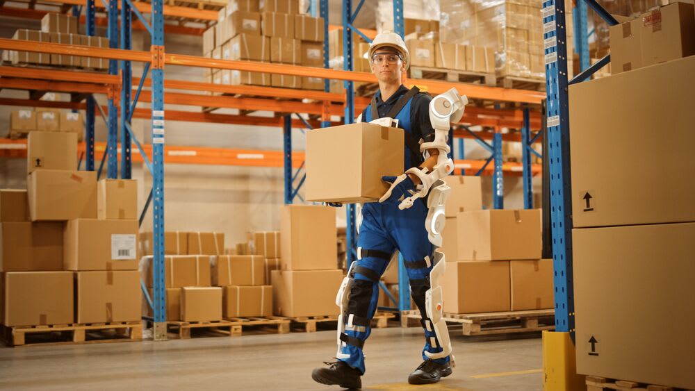 Man with exoskeleton in warehouse