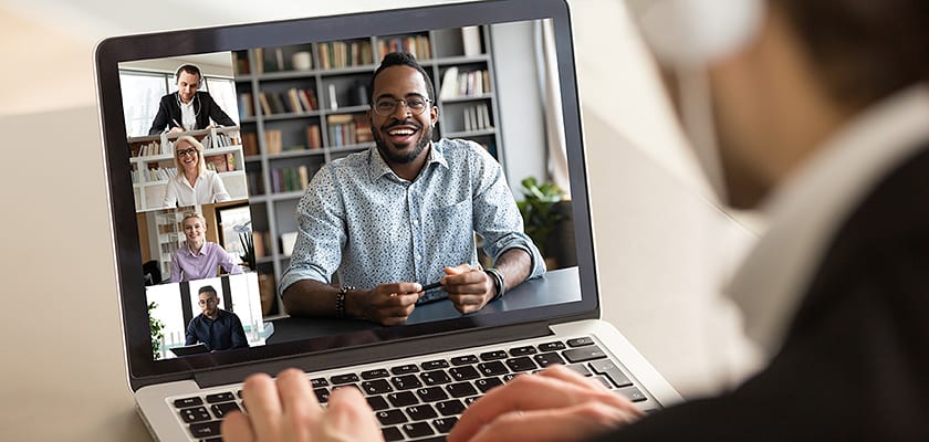 Person watching a webinar on her laptop smiling