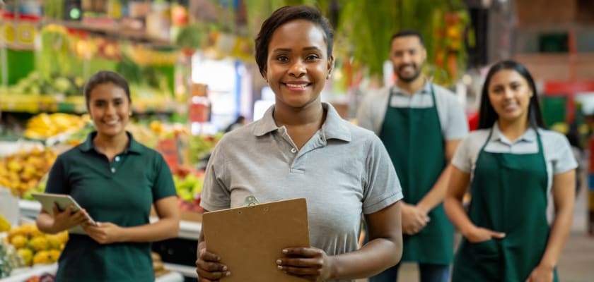 Grocery manager leading a group of employees.