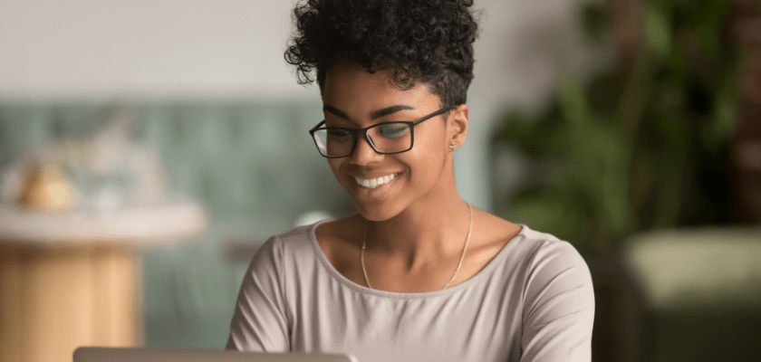 Person watching a webinar on her laptop smiling