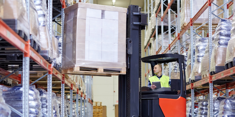 Person working in a warehouse using a lift truck.