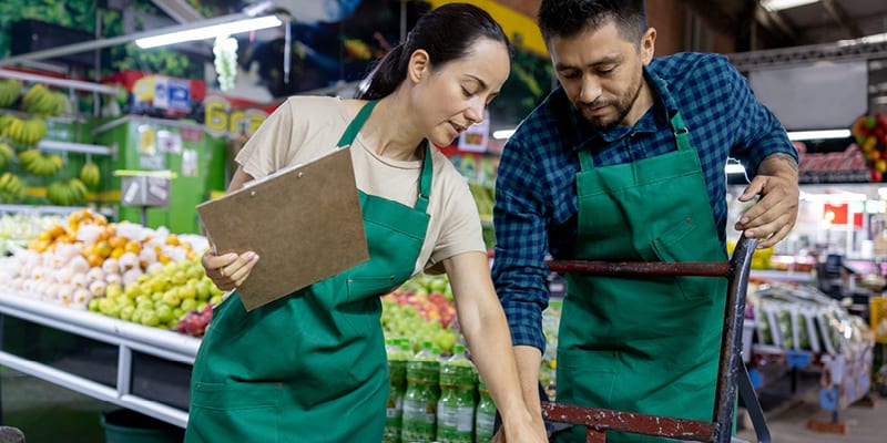grocery store workers sorting through produce