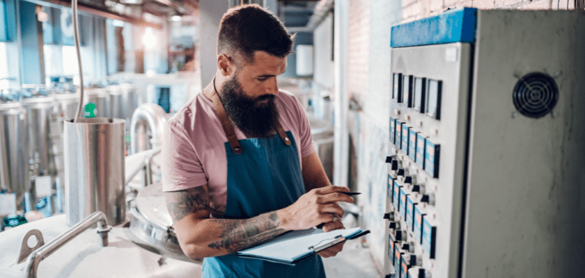 Craft brewery worker reviewing safety compliance.