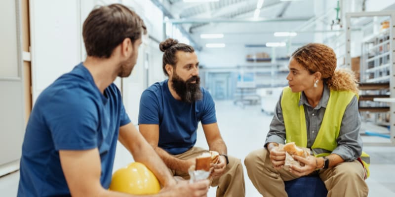 Three coworkers having a discussion sitting down.