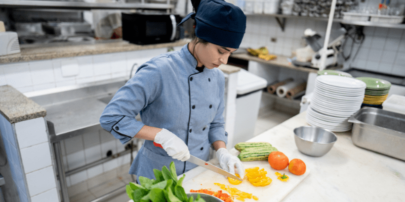 Chef chopping vegetables in a commercial kitchen.