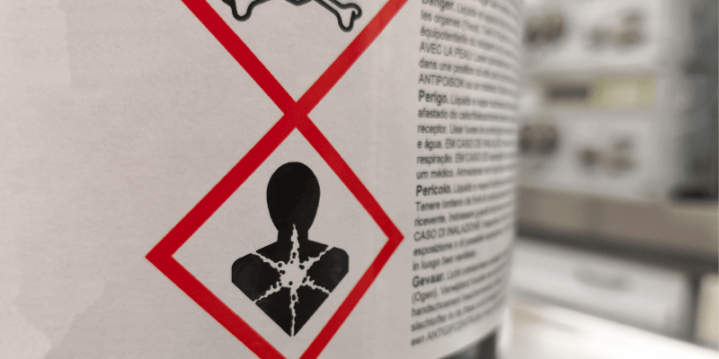 Hazardous workplace chemicals with warning sign.