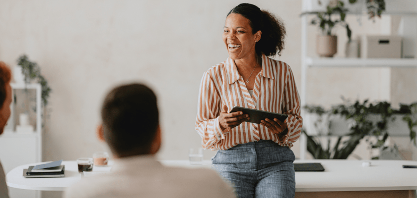 Smiling Businesswoman Leading Office Meeting with Colleagues