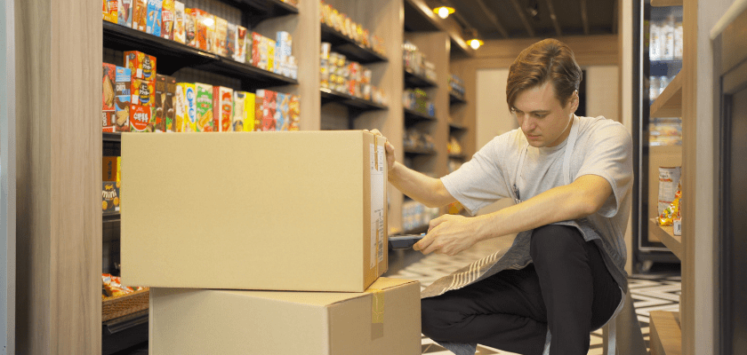 Worker in a grocery store organizing boxes.