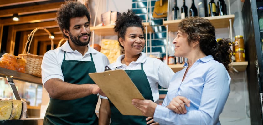 Grocery employees talking with a consultant.