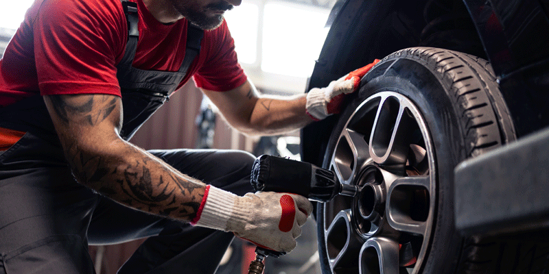 employee servicing a tire in a vehicle repair shop