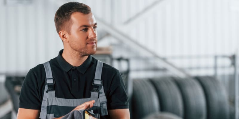 Man in uniform is working in the auto service 