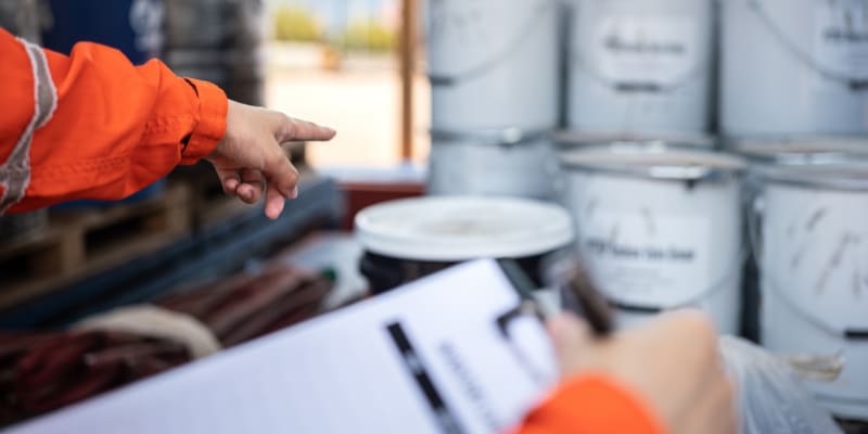 Safety audit at the chemical storage area. Worker pointing at chemical storage.