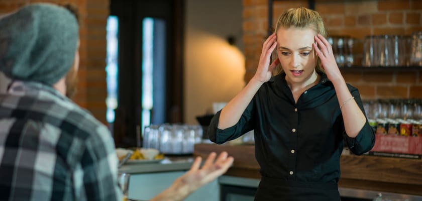 Server being appraoched by an aggressive customer in a restaurant.