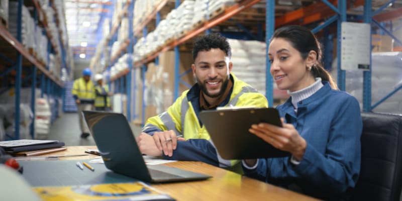 2 workers having a meeting in a warehouse.