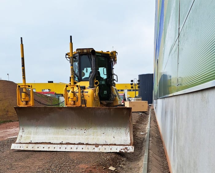 A dozer next to a building.