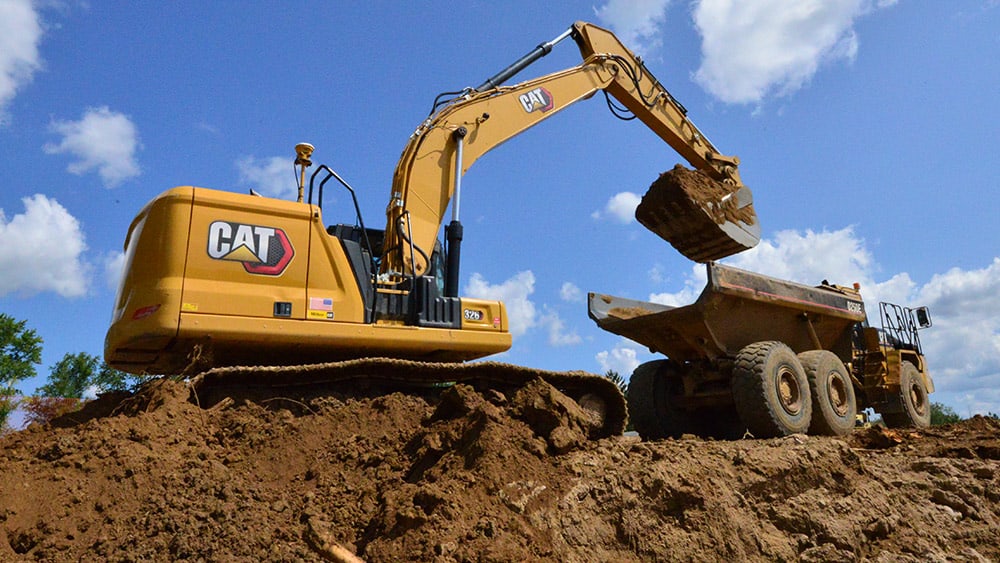 Excavator with machine control loading a truck 