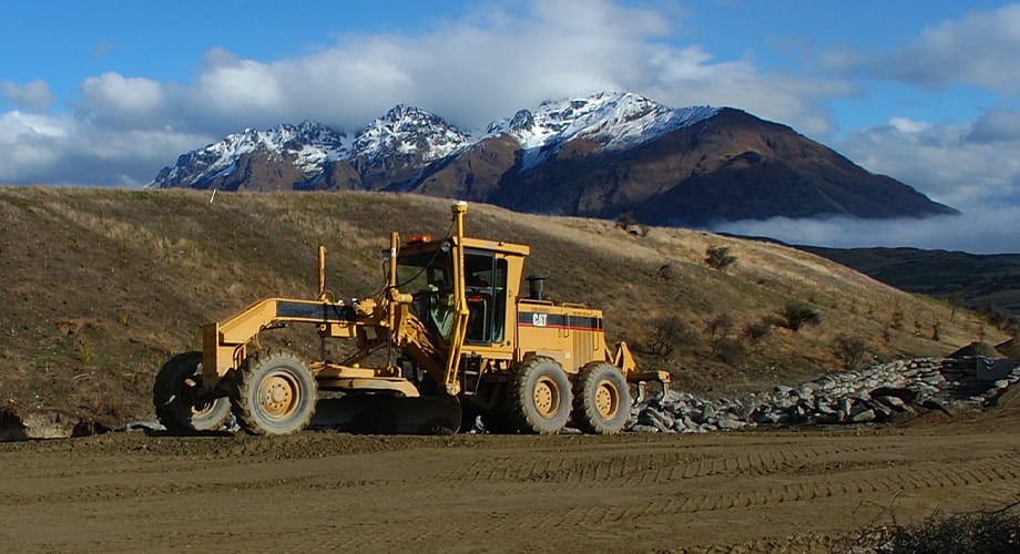 A machine with Trimble machine control maneuvers around a jobsite.