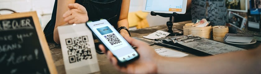 Customer using their mobile phone to scan a QR code