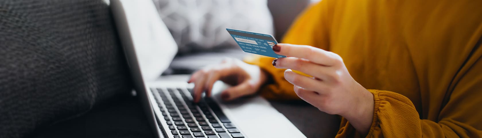 Person typing their credit card information onto their laptop