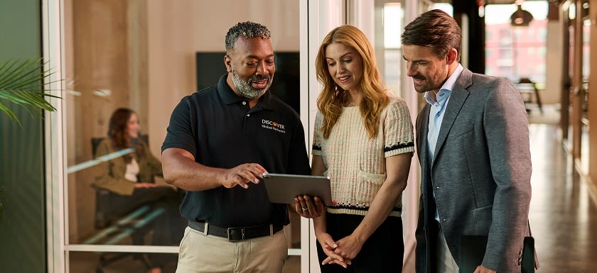 Discover business consultant presenting ideas on a tablet to a professional team in a modern office setting.