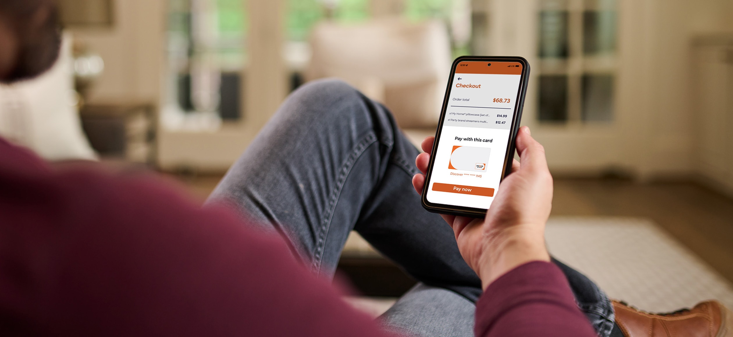 Person sitting on couch shopping on mobile device