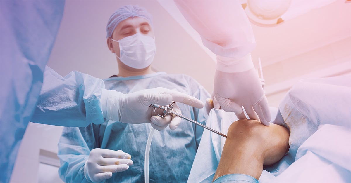 A surgical team performs a knee arthroscopy.