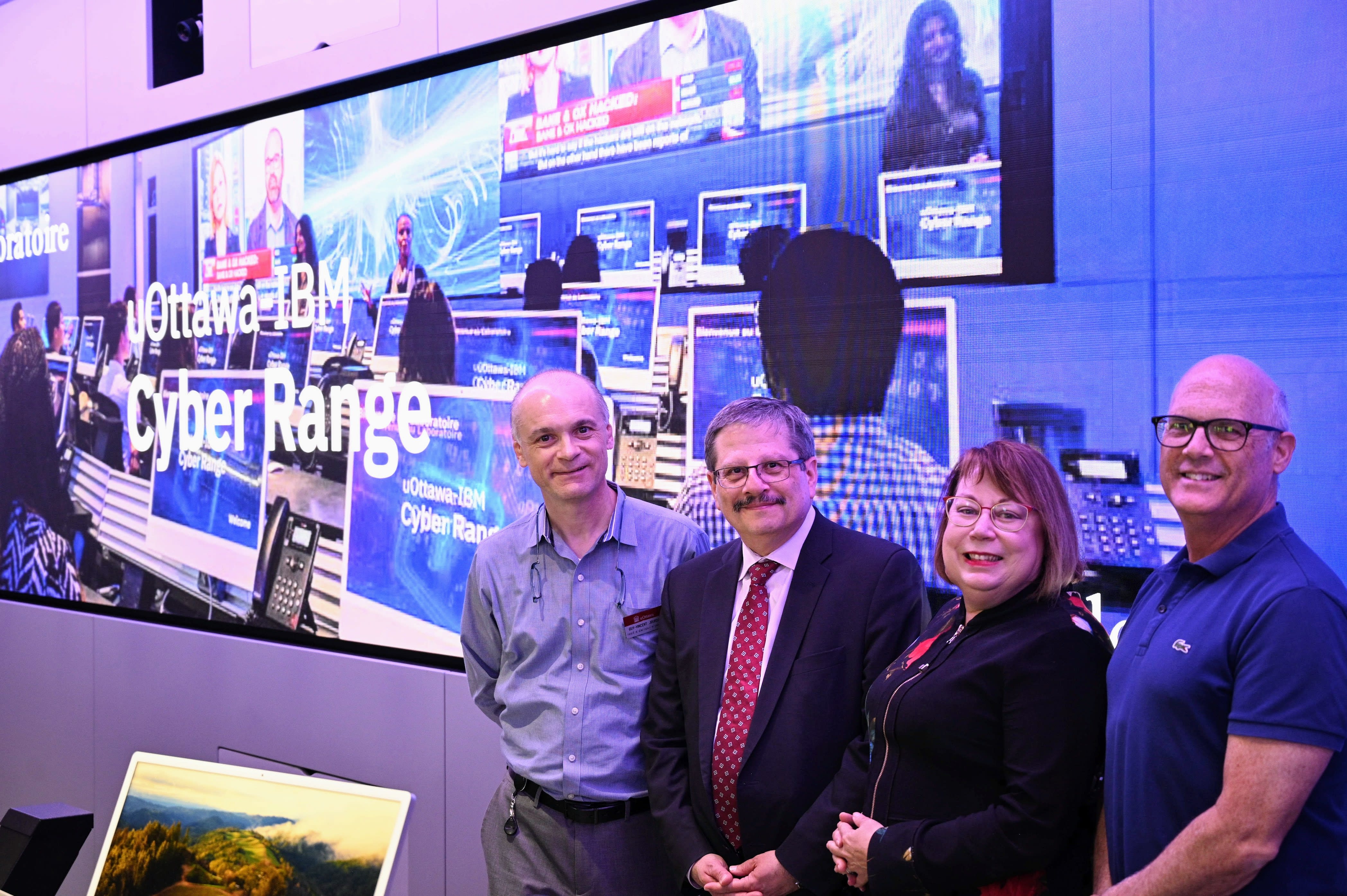 Four individuals (Guy-Vincent Jourdan, Sami Khoury, Jennifer Irish, and James Clemens) pose for a group photo at the uOttawa-IBM Cyber Range.