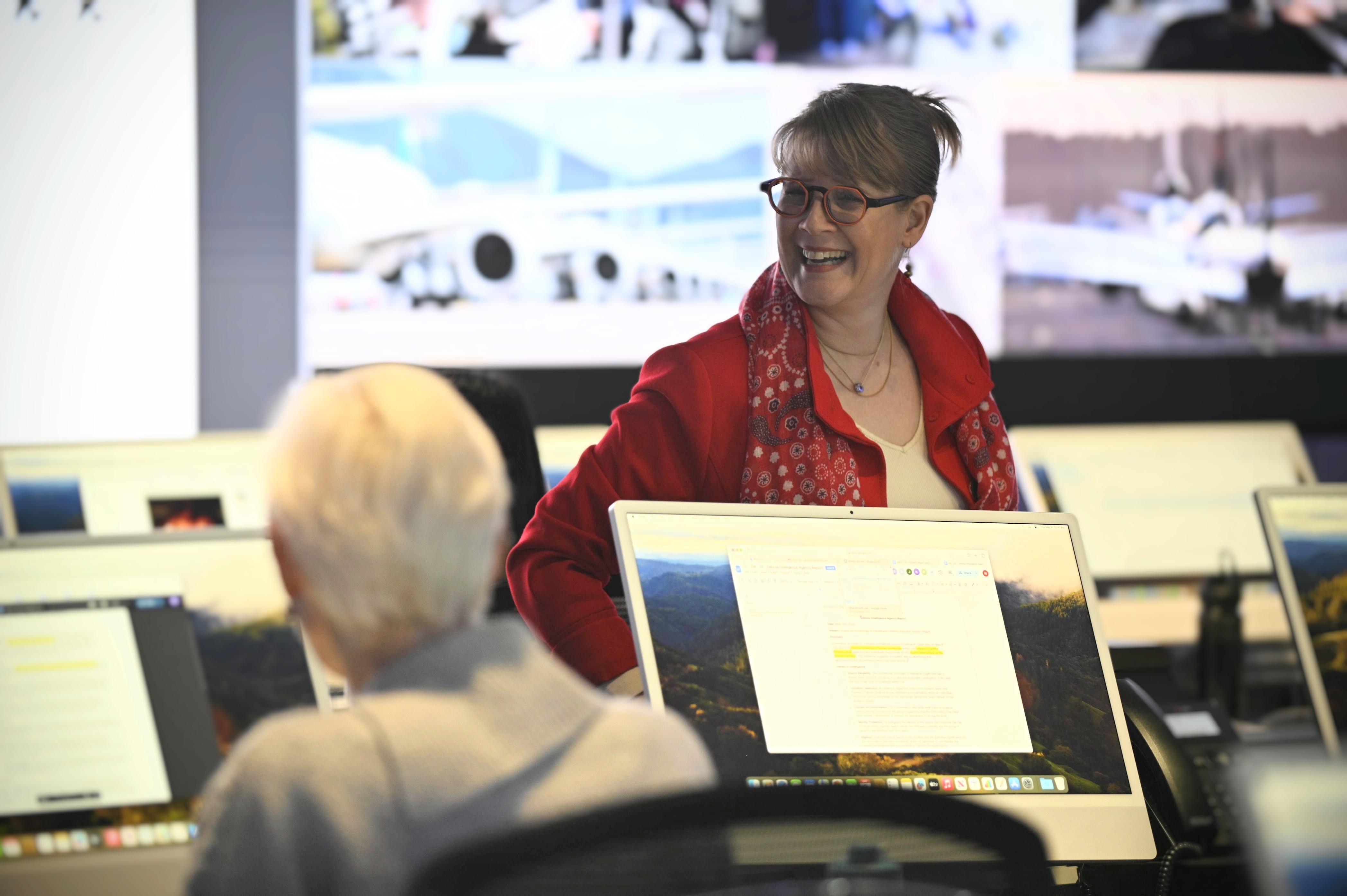 A facilitator (Marie Careau) speaks with a participant at the uOttawa-IBM Cyber Range.