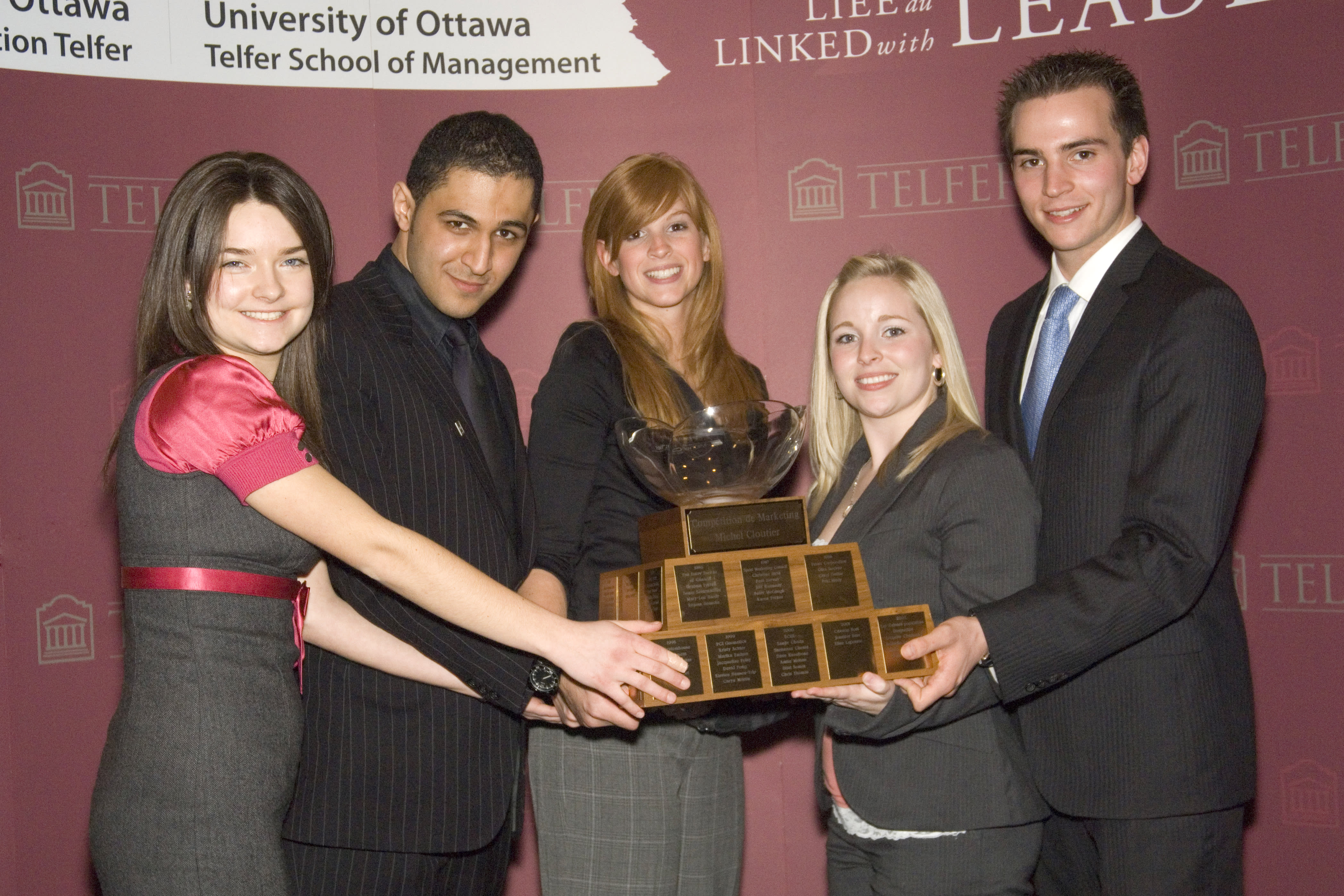 Amanda Richardson and three students holding a trophy and smiling.