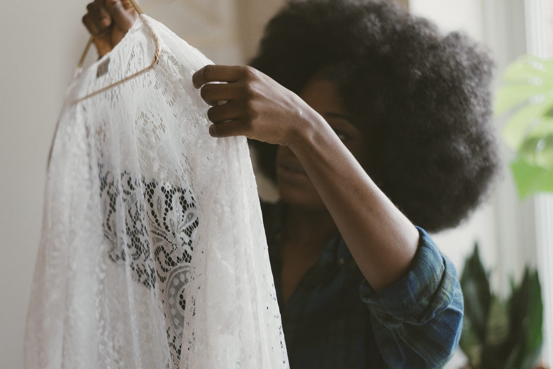 Chizoba Martin holding up a piece of lace fabric.