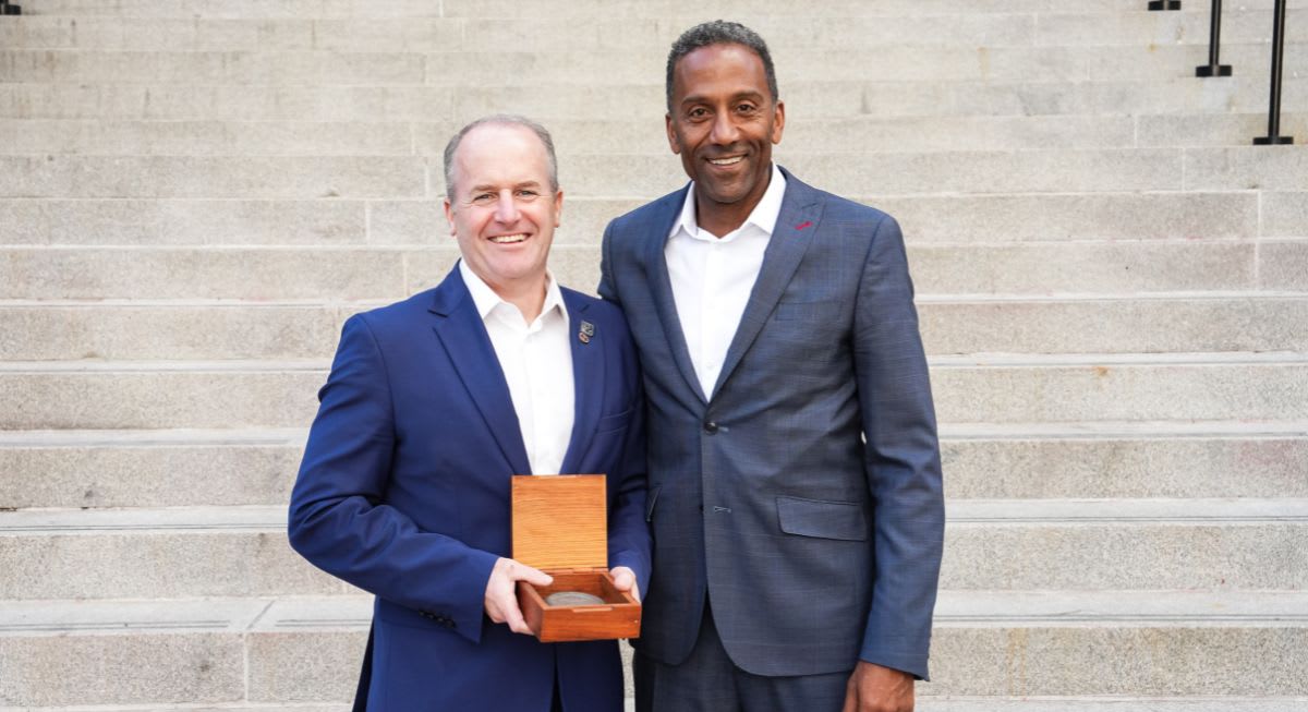 Cameron Love holding the R. Trudeau Medal beside Dean Brutus