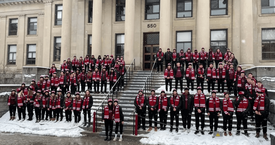 Participants dressed in black with matching red scarves on the Tabaret stairs during the winter